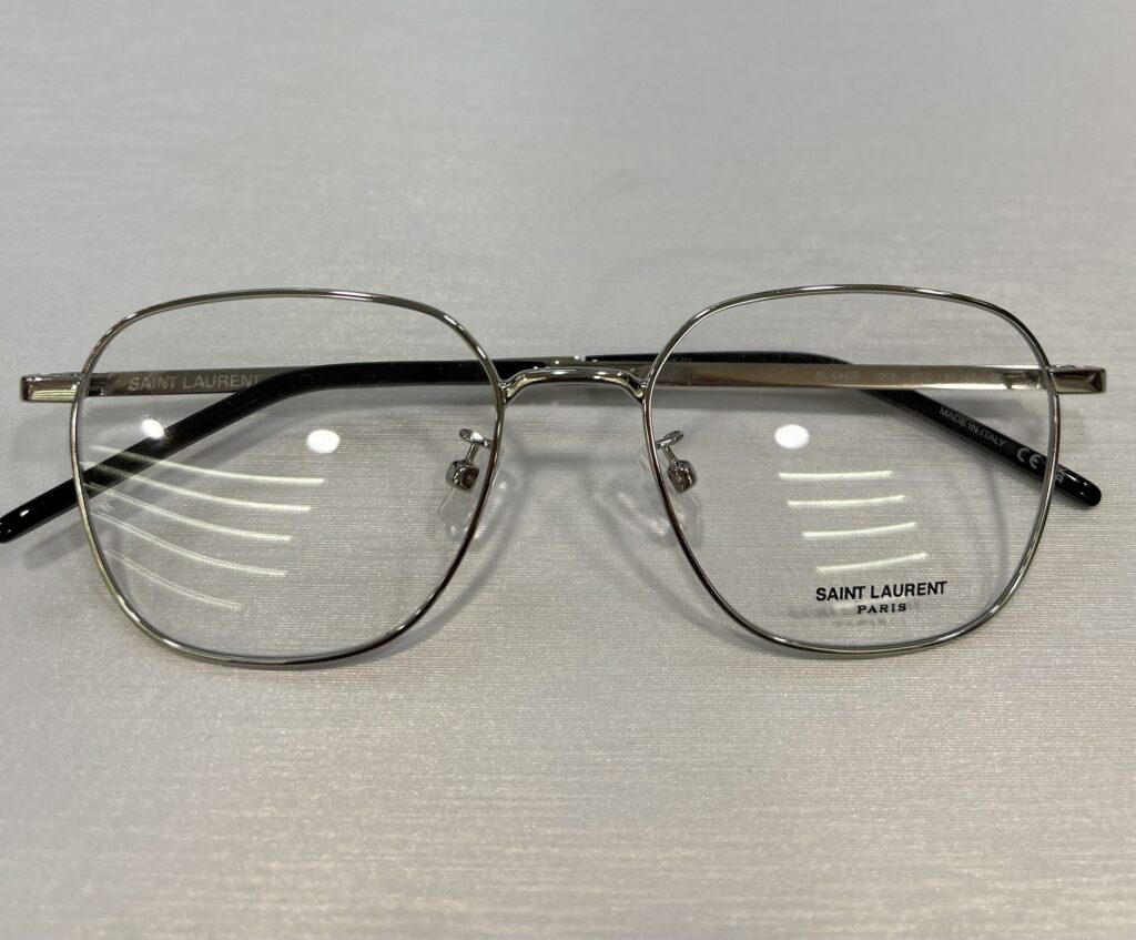 A pair of Saint Laurent Paris metal-framed 眼鏡 with rectangular lenses is positioned on a light surface, perfect for those with 心儀 taste.