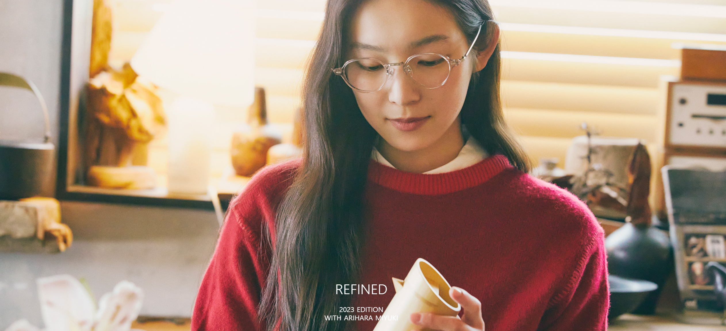 A woman wearing glasses is holding a piece of paper while auto drafting.